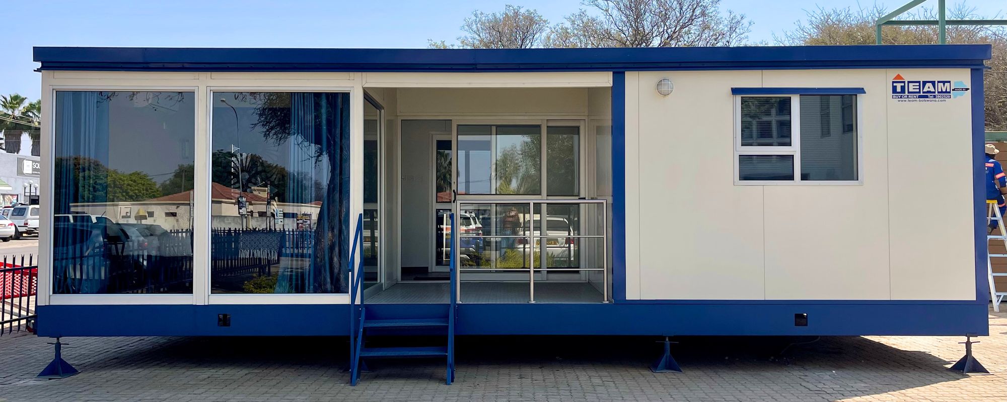 A TEAM mobile unit with a glazed frontage and balcony at the Phakalane yard